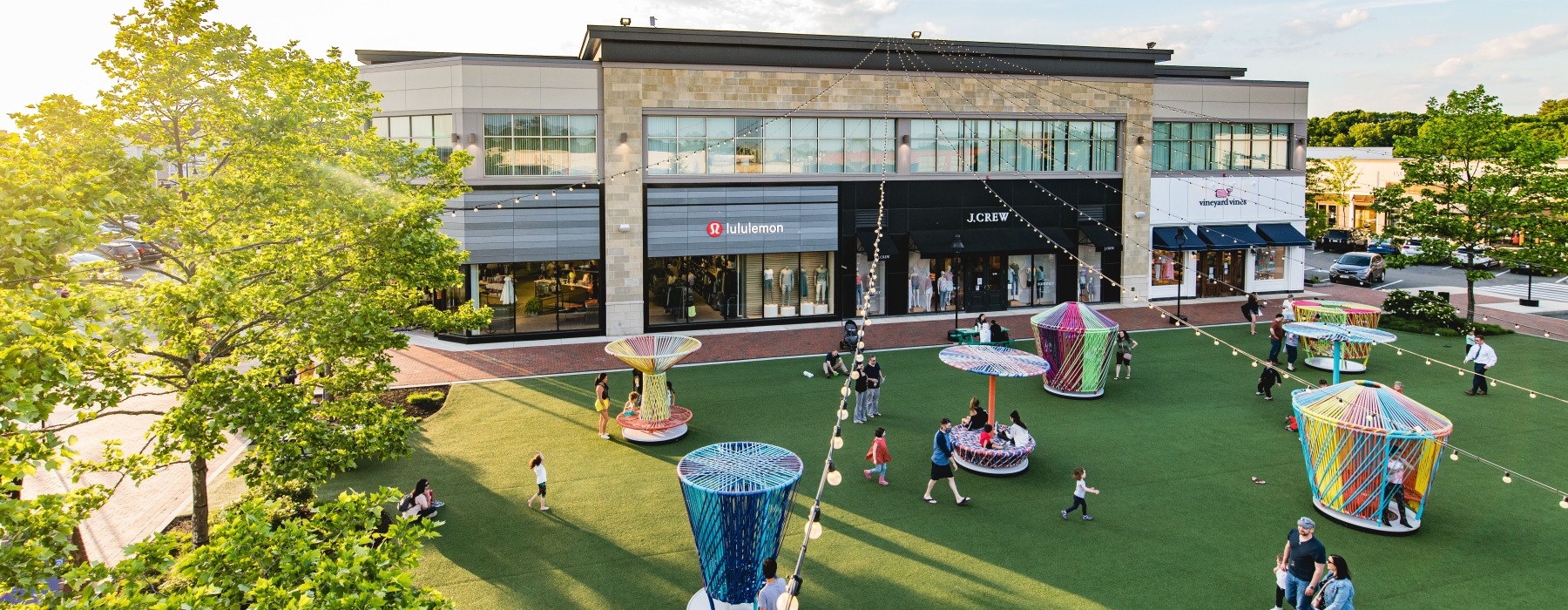 People walking on store front lawn 